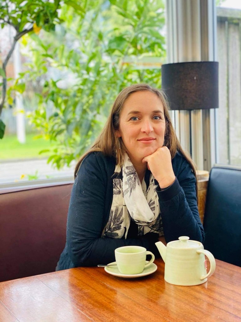 Kirsten Le Harivel sitting at a table with a cup of tea.